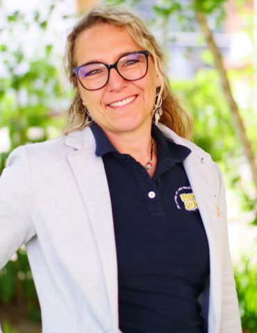 a woman wearing glasses and a grey blazer