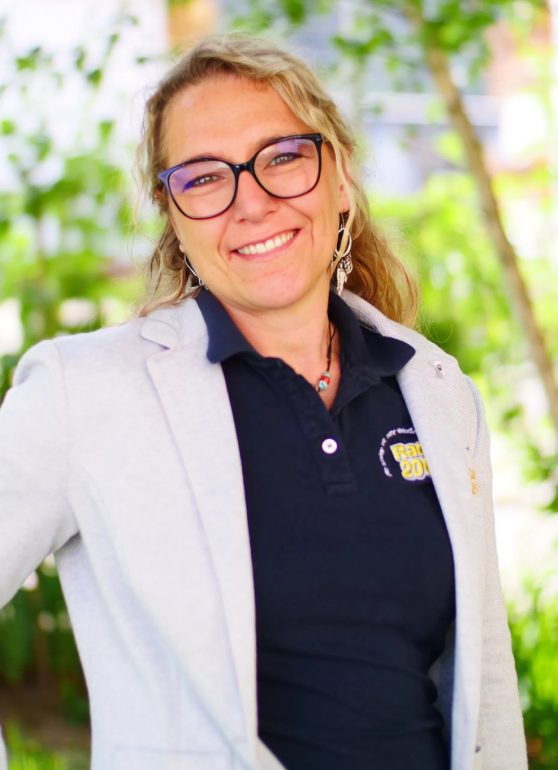a woman wearing glasses and a grey blazer